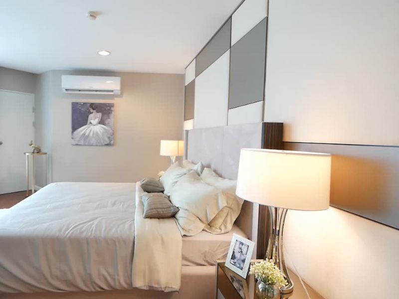 elegantna spavaća soba sa svetlom posteljinom, zidovima i slikama